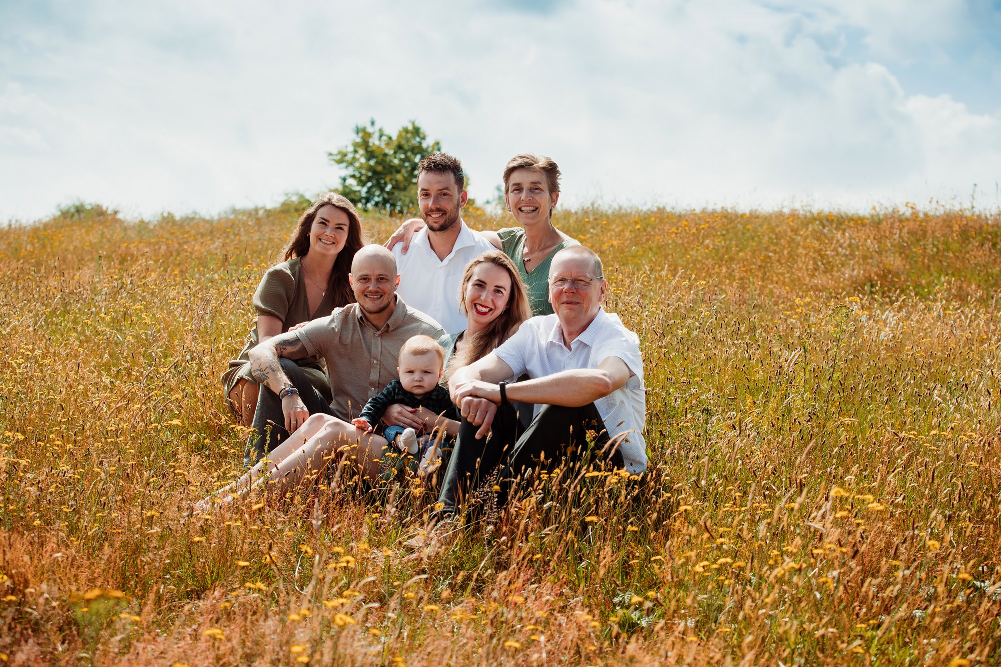 Familie zittend in een veld bij het einde van de dag